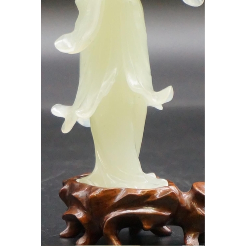 1315 - A Chinese carved celadon jade figure of Guanyin, 15cm high, on fitted wood stand, (s.d.).... 