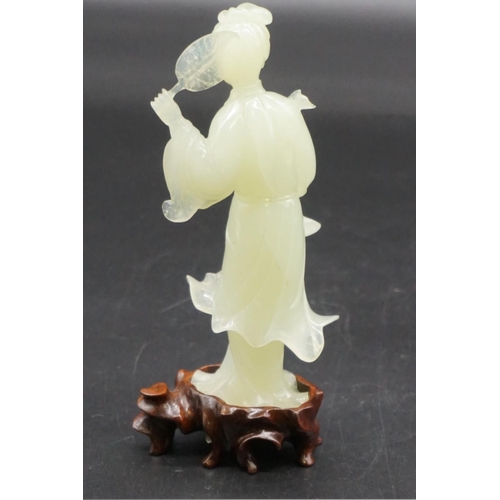 1315 - A Chinese carved celadon jade figure of Guanyin, 15cm high, on fitted wood stand, (s.d.).... 