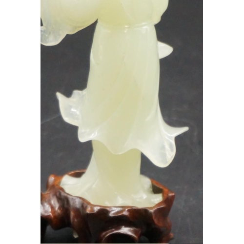 1315 - A Chinese carved celadon jade figure of Guanyin, 15cm high, on fitted wood stand, (s.d.).... 