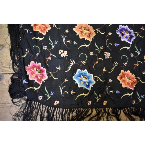 1380 - A Chinese embroidered black silk shawl, with tasselled fringe.