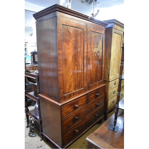 1436 - An early 19th century figured mahogany linen press, the pair of panelled doors enclosing four slidin... 