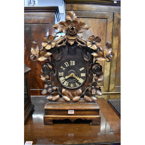 1441 - A large 19th century Black Forest carved walnut cuckoo clock, striking on a gong, 59cm high, with as... 