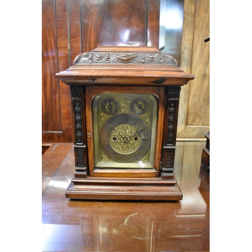 1442 - A late 19th century carved walnut twin fusee mantel clock, 34cm high, with pendulum. ... 