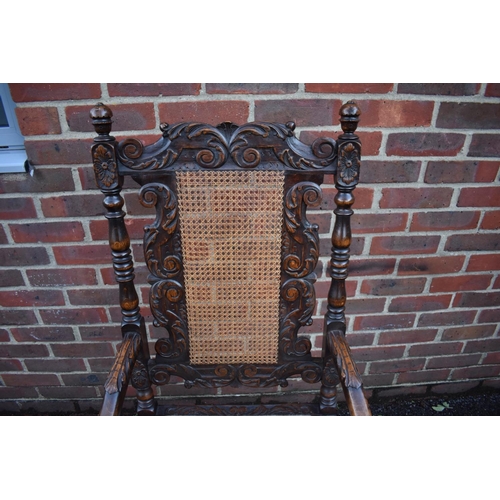 1457 - A late Victorian carved oak and cane open armchair, in the Carolean style.