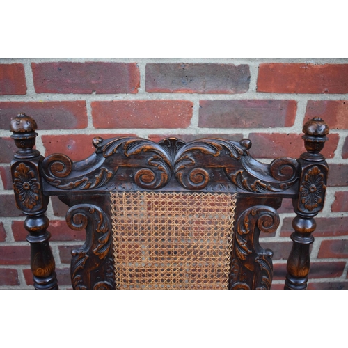 1457 - A late Victorian carved oak and cane open armchair, in the Carolean style.