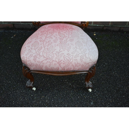 1458 - A Victorian carved walnut and pink damask nursing chair.... 