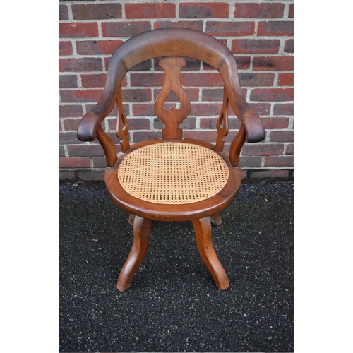 1460 - A late Victorian mahogany and cane revolving desk chair. 