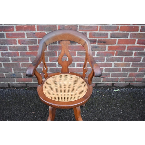 1460 - A late Victorian mahogany and cane revolving desk chair. 