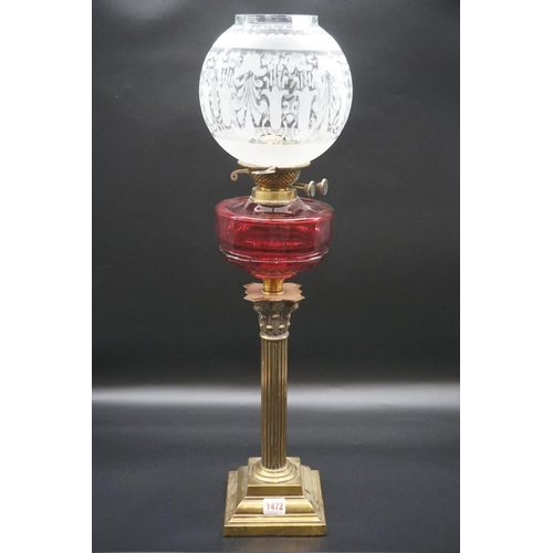 1472 - An antique brass Corinthian column oil lamp, with ruby glass reservoir and etched shade, height incl... 