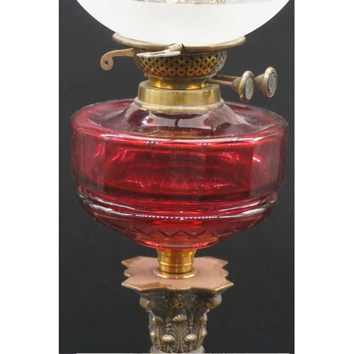 1472 - An antique brass Corinthian column oil lamp, with ruby glass reservoir and etched shade, height incl... 