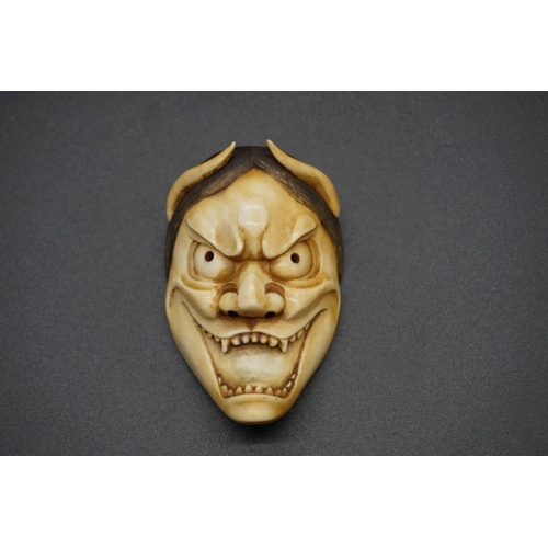 1243 - A good Japanese carved ivory 'Oni' Noh mask okimono, 19th century, 6.8cm.