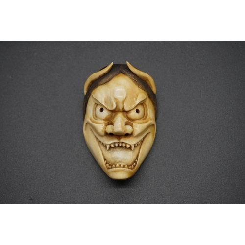 1243 - A good Japanese carved ivory 'Oni' Noh mask okimono, 19th century, 6.8cm.