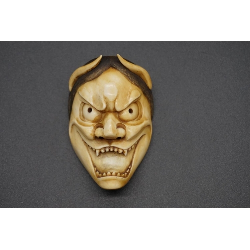 1243 - A good Japanese carved ivory 'Oni' Noh mask okimono, 19th century, 6.8cm.