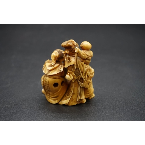 1247 - A good and large Japanese carved ivory netsuke figure group, 19th century, depicting a man, woman an... 