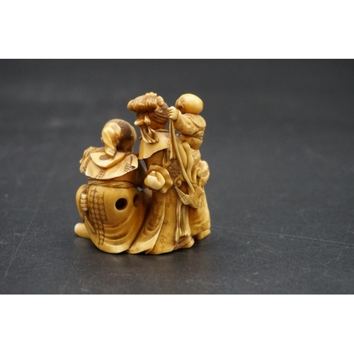 1247 - A good and large Japanese carved ivory netsuke figure group, 19th century, depicting a man, woman an... 