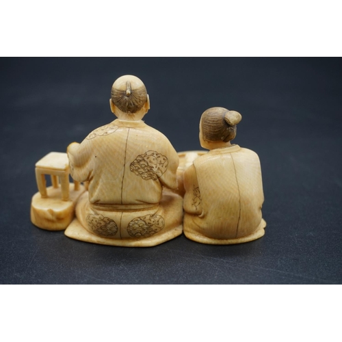 1248 - A Japanese carved ivory okimono, Meiji, depicting two seated figures, one holding a brush, signed, s... 