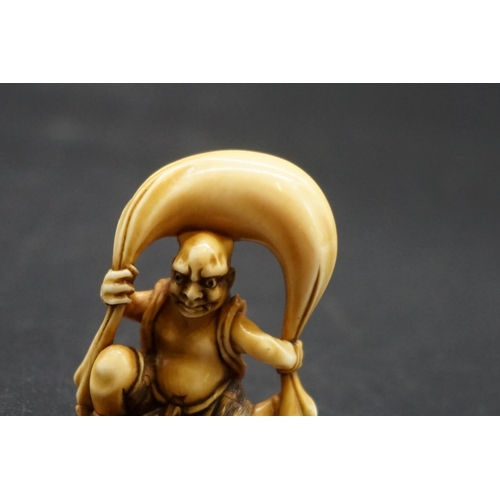 1251 - A good Japanese carved ivory netsuke, 19th century, depicting Fujin with his bag of wind, 4.5cm high... 