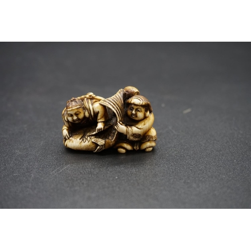 1253 - A good Japanese carved ivory netsuke, Edo, depicting Daikoku and Ebisu on a large sea bream, 4.4cm w... 