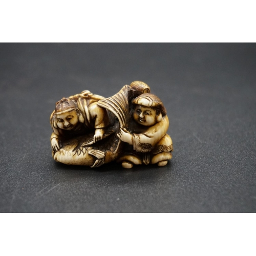 1253 - A good Japanese carved ivory netsuke, Edo, depicting Daikoku and Ebisu on a large sea bream, 4.4cm w... 