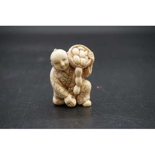 1256 - A Japanese carved ivory netsuke, early 20th century, depicting a man with a basket of fruit, 4.5cm h... 