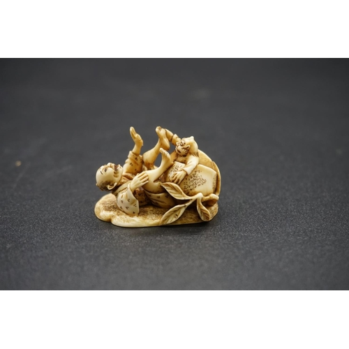 1258 - A good Japanese carved ivory netsuke, by Ryoji, 19th century, depicting a man and demon in comical p... 