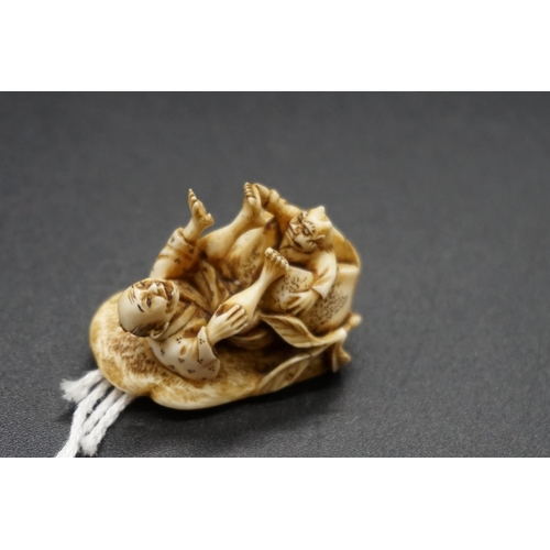 1258 - A good Japanese carved ivory netsuke, by Ryoji, 19th century, depicting a man and demon in comical p... 