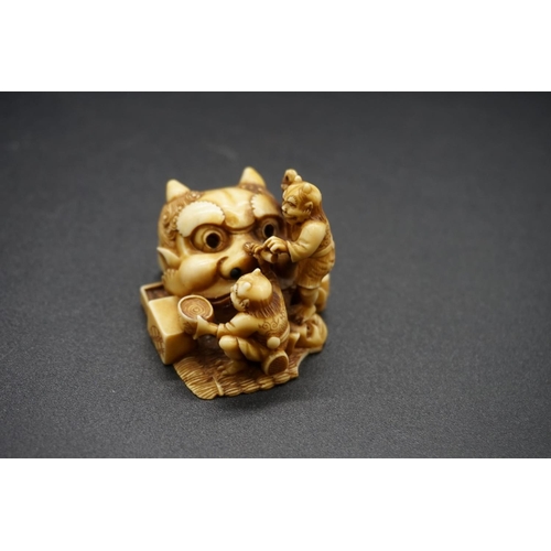 1259 - A good Japanese carved ivory netsuke, by Ryoji, 19th century, depicting two demons and a large Noh m... 