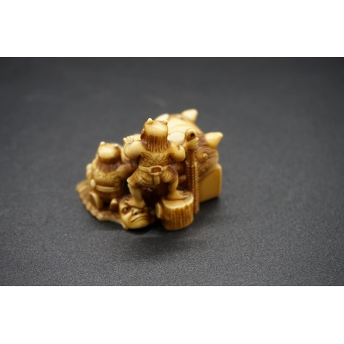 1259 - A good Japanese carved ivory netsuke, by Ryoji, 19th century, depicting two demons and a large Noh m... 