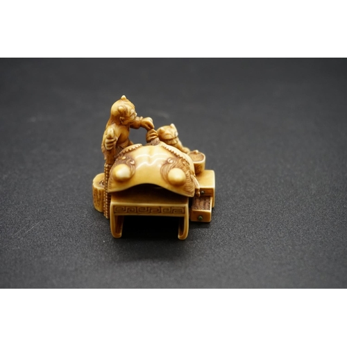 1259 - A good Japanese carved ivory netsuke, by Ryoji, 19th century, depicting two demons and a large Noh m... 