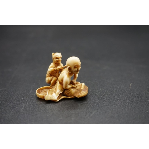 1261 - A good and unusual Japanese carved ivory netsuke, Edo, depicting a seated man receiving treatment fr... 