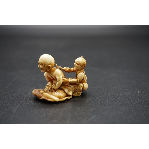 1261 - A good and unusual Japanese carved ivory netsuke, Edo, depicting a seated man receiving treatment fr... 