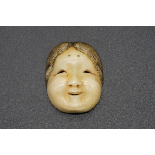 1262 - A good Japanese carved ivory Noh mask netsuke, probably Edo, depicting a lady with ribbon tied back,... 