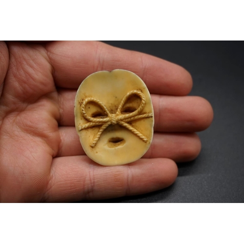 1262 - A good Japanese carved ivory Noh mask netsuke, probably Edo, depicting a lady with ribbon tied back,... 