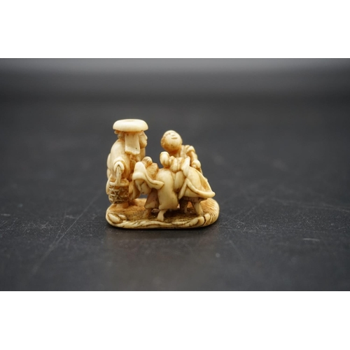 1263 - An unusual Japanese carved ivory netsuke, probably Edo, depicting a cow like woman, with man and chi... 