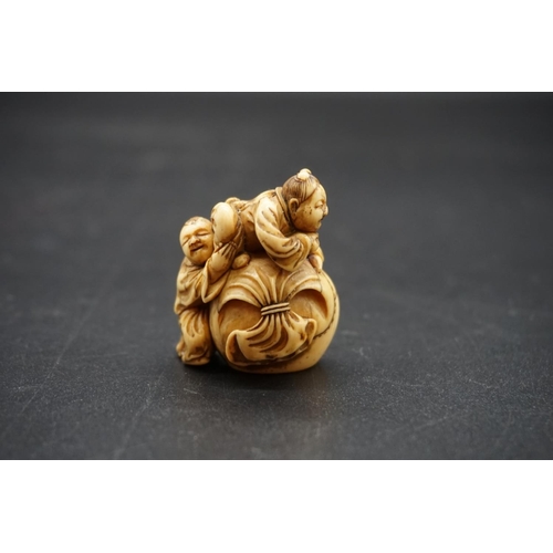 1265 - A good Japanese carved ivory netsuke, Edo, depicting two figure with a large treasure sack, 4cm high... 