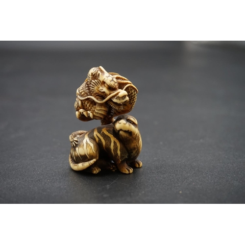 1267 - A good Japanese carved ivory netsuke or okimono, Edo, depicting a dragon and tiger, 5cm high.... 