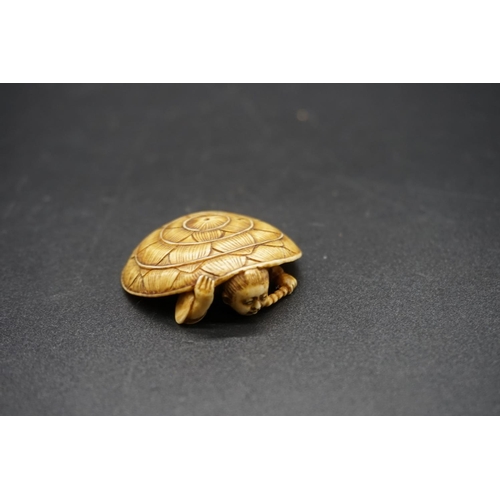 1269 - A Japanese carved ivory netsuke, Meiji, depicting a man crouching under a large straw hat, 4.3cm wid... 