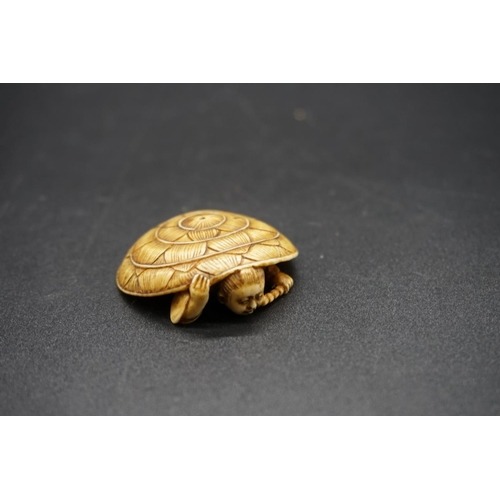 1269 - A Japanese carved ivory netsuke, Meiji, depicting a man crouching under a large straw hat, 4.3cm wid... 