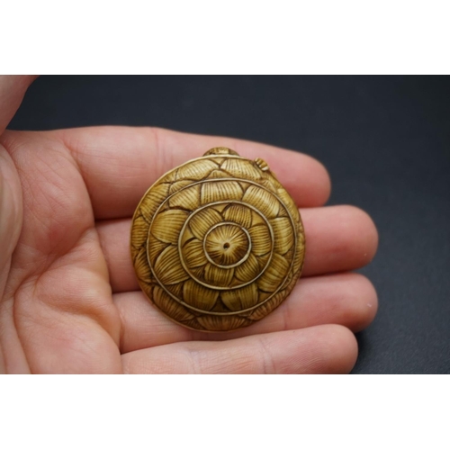 1269 - A Japanese carved ivory netsuke, Meiji, depicting a man crouching under a large straw hat, 4.3cm wid... 