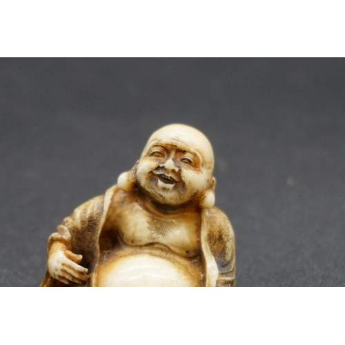 1279 - A Japanese carved ivory netsuke of Hotei, Meiji, signed, 3.7cm high.