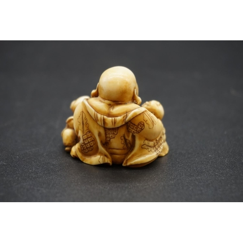 1280 - A good Japanese carved ivory netsuke, Edo, depicting Hotei and two Karako, signed, 4cm high.... 