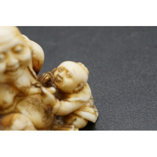 1280 - A good Japanese carved ivory netsuke, Edo, depicting Hotei and two Karako, signed, 4cm high.... 