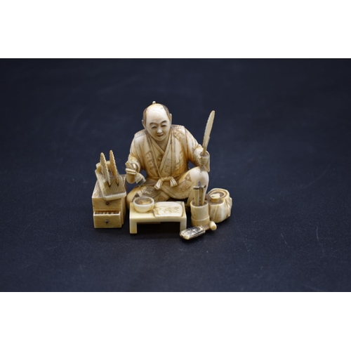 1283 - A Japanese carved ivory okimono, Meiji, depicting a fan painter, signed on inset tablet, 6.8cm wide.... 