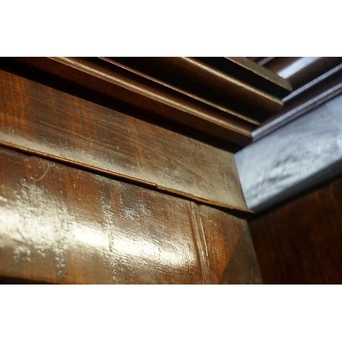 1436 - An early 19th century figured mahogany linen press, the pair of panelled doors enclosing four slidin... 