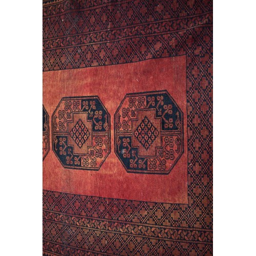 1065 - An Afghan rug, having four central medallions, 220cm x 152cm.