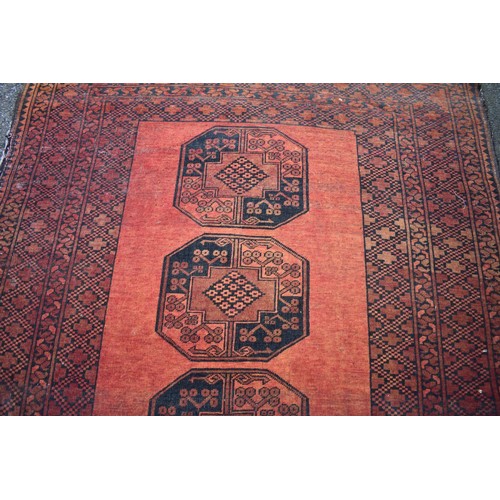 1065 - An Afghan rug, having four central medallions, 220cm x 152cm.