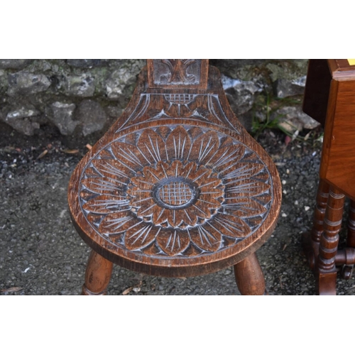 1060 - A carved oak spinning stool; together with a mahogany Sutherland table.