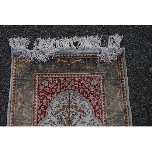 1078 - A small Persian silk prayer rug, decorated with birds, trees and flowers, 72cm x 52cm.... 