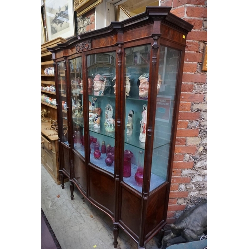 1082 - A good early 20th century mahogany serpentine fronted display cabinet, 167cm wide.