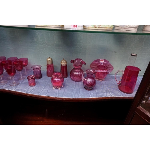 1085 - A collection of Victorian cranberry glass, to include: vases and two electroplate mounted casters. (... 